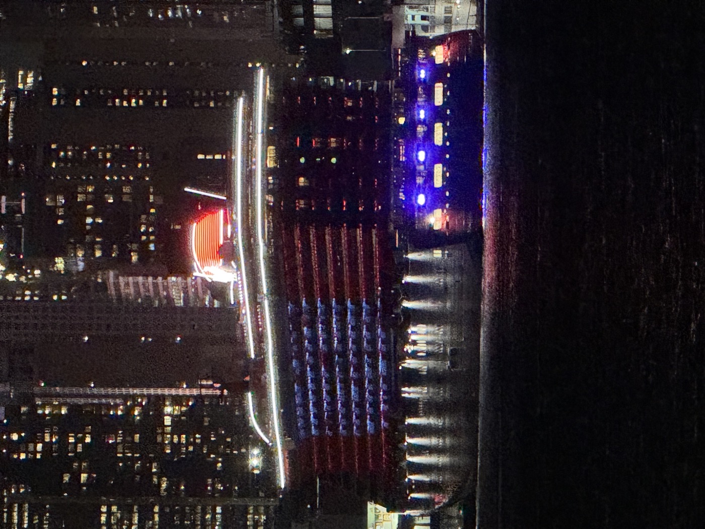 Brilliant Lady lit up red, white, and blue at night in New York Harbor