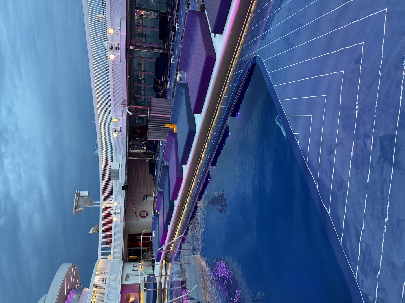 Brilliant Lady's pool deck at dusk, purple and blue lights reflecting on the water