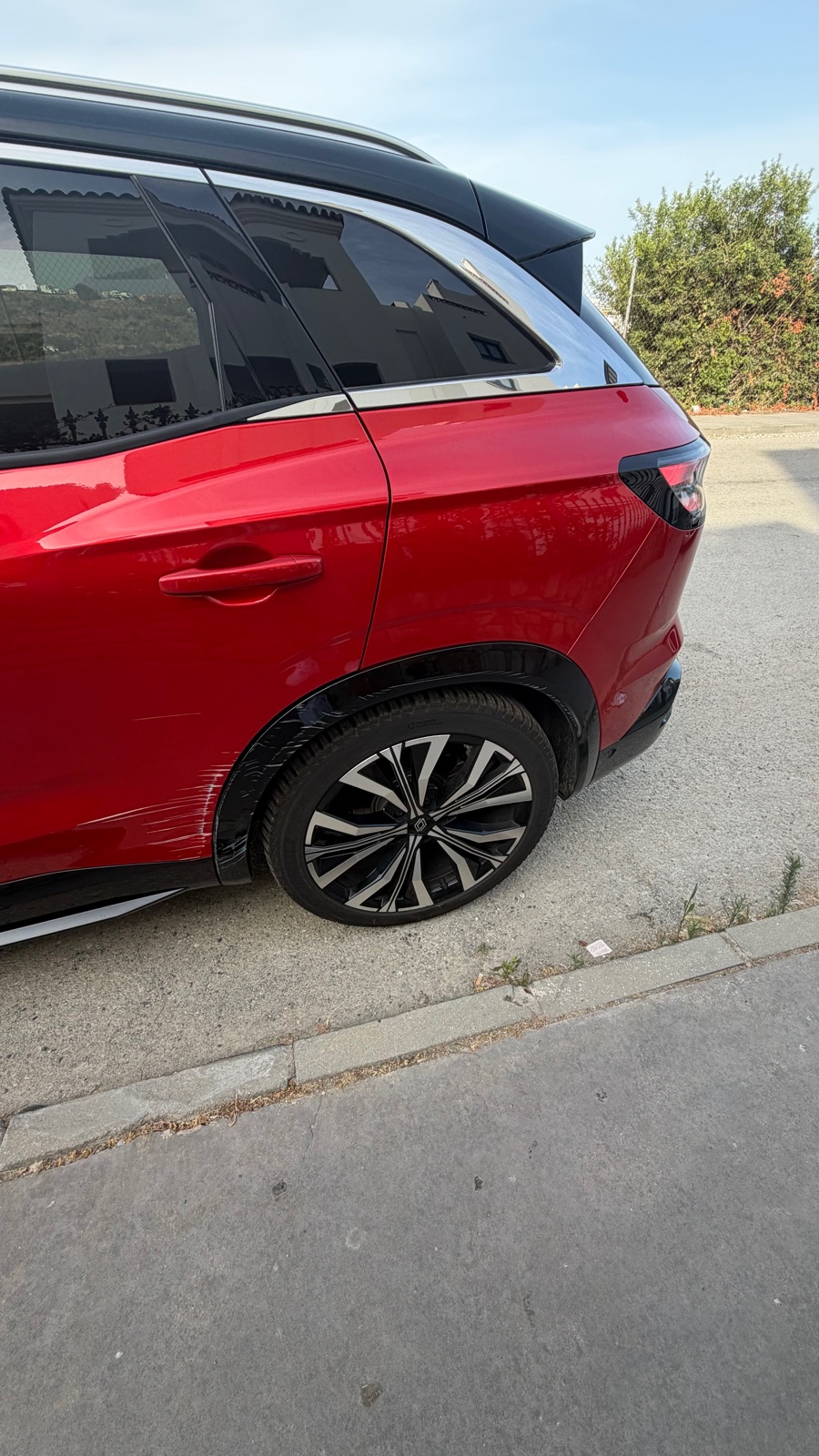 The same damage seen from further back, showing the whole rear quarter of the car