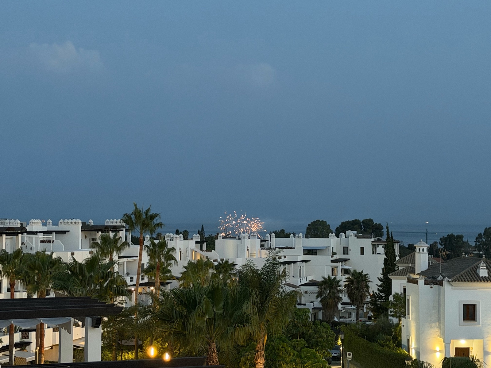 Fireworks over the rooftops at dusk, seen from the terrace