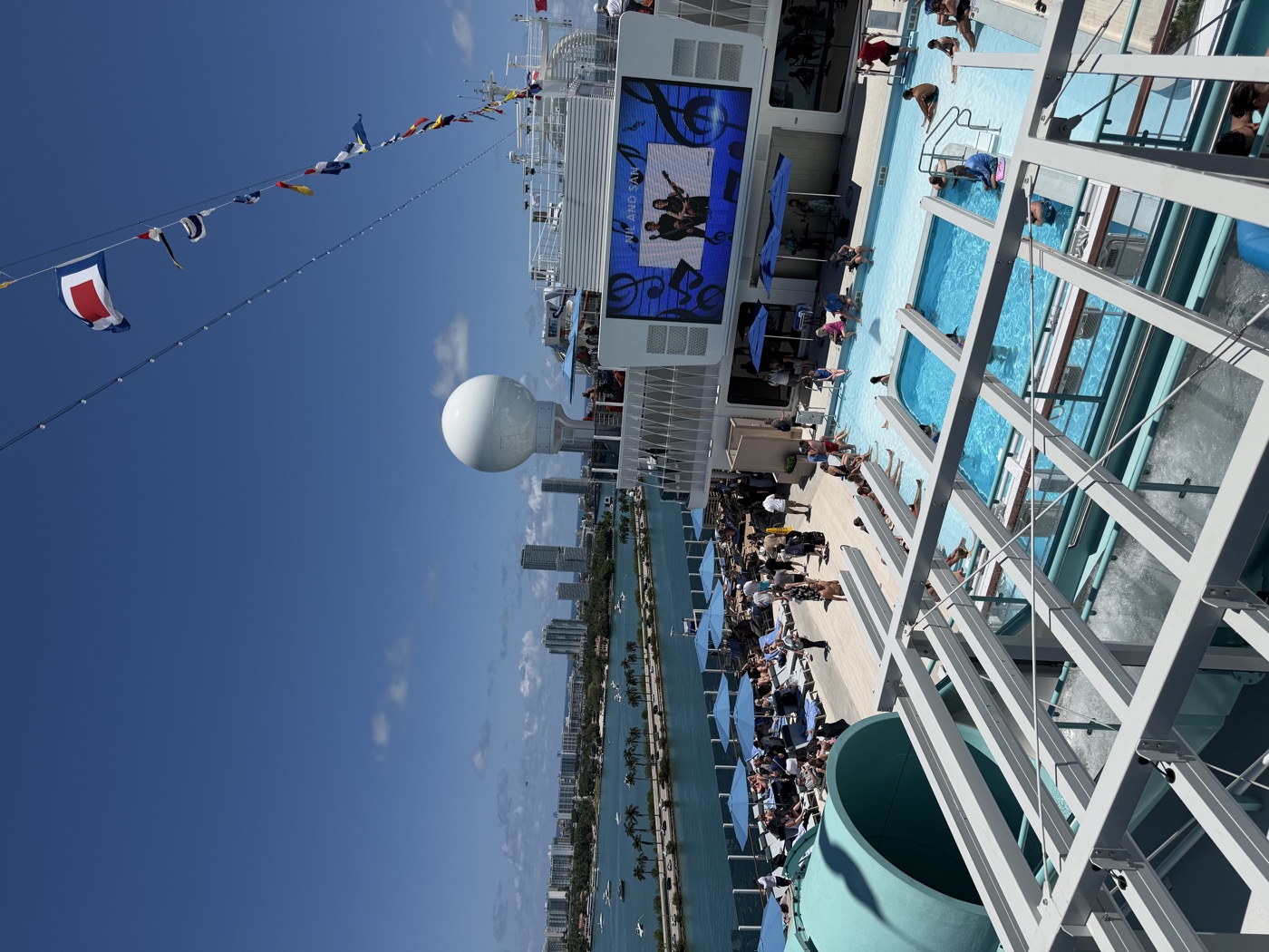 Pool deck on Norwegian Luna with maritime flag bunting and the main screen