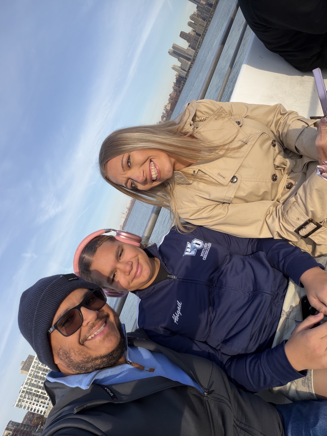 Family selfie at the Hudson River with the NYC skyline behind them