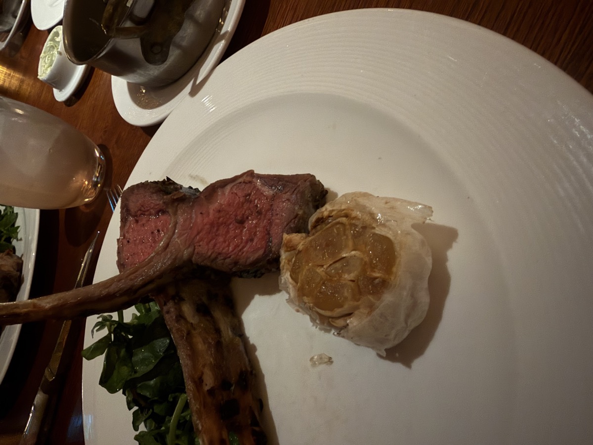 Lamb chop with a roasted head of garlic at a Virgin Voyages restaurant