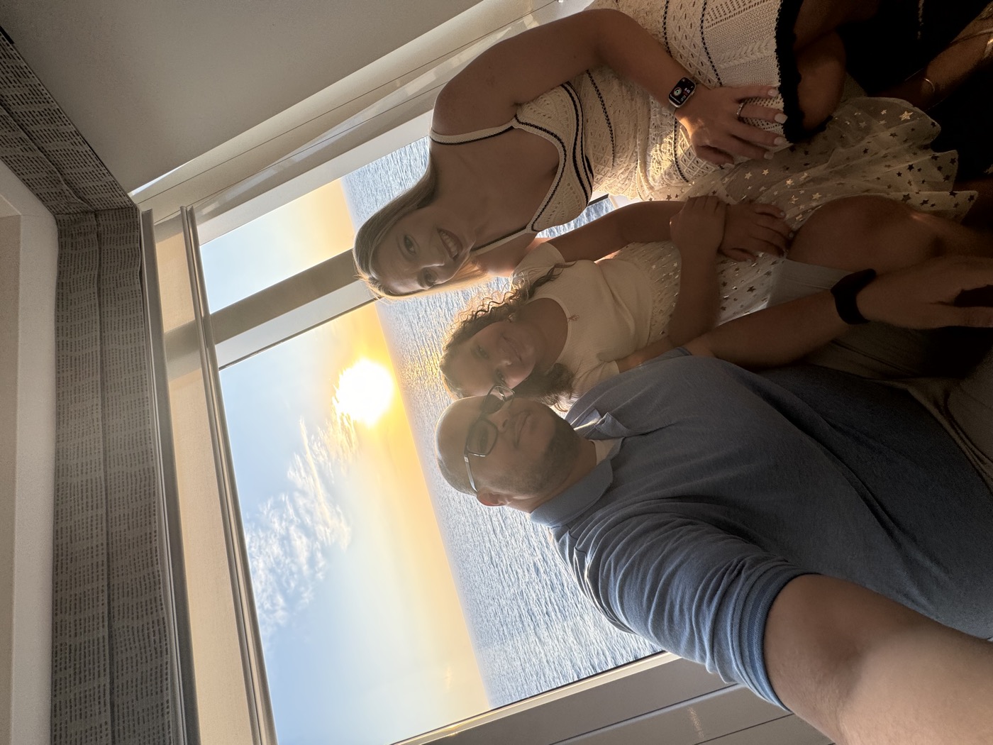 Family in the Ultimate Panoramic Suite watching the sunset through the floor-to-ceiling window